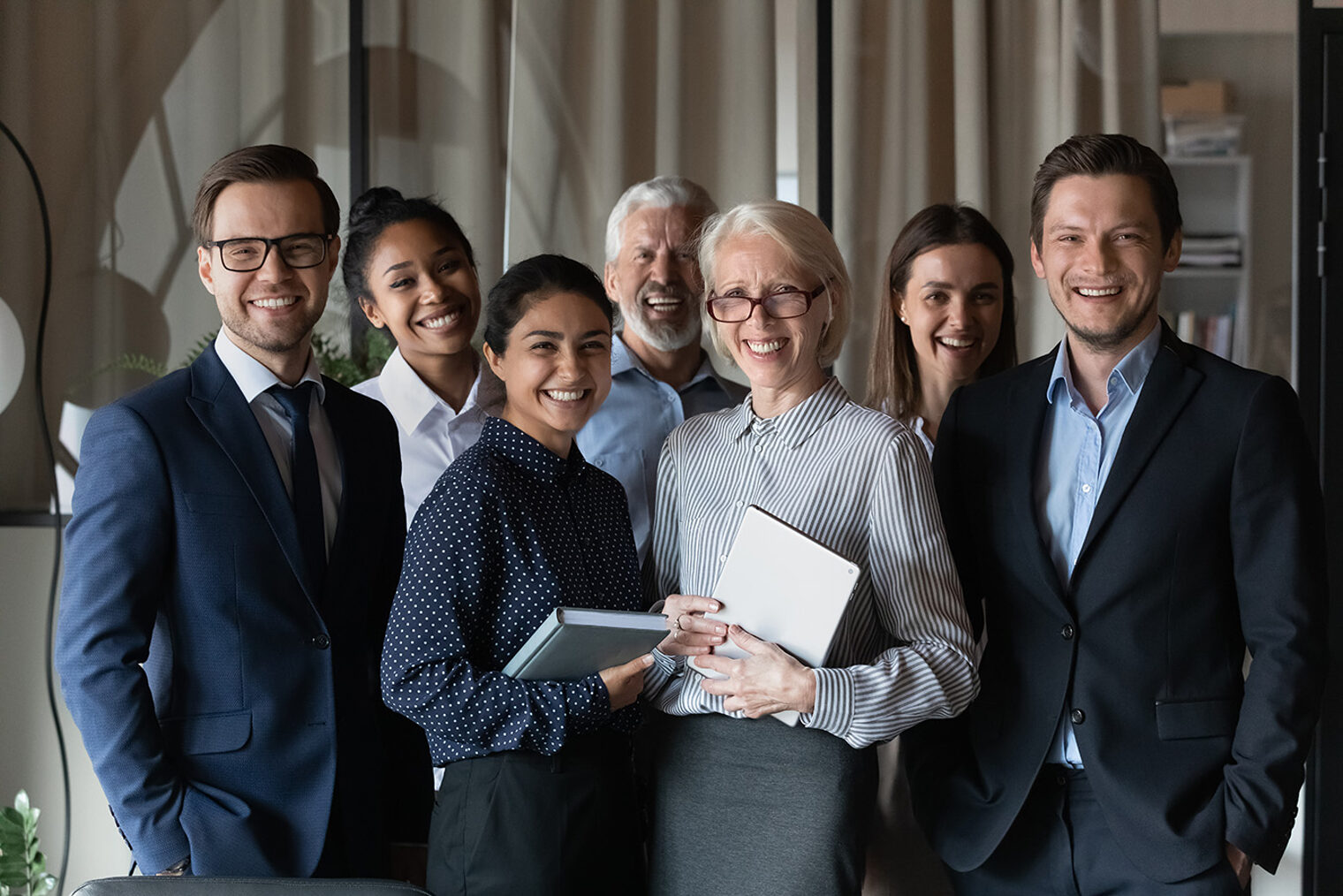 Human resource. Group portrait of smiling employees friendly team of diverse age race gender standing in office together. Successful motivated old young age multiethnic corporate staff look at camera Schlagwort(e): adult, aged, asian, business, camera, client, colleague, coworker, customer, different, diverse, employee, ethnicity, friendly, generation, group, happy, hr, indian, investor, job, leader, looking, man, manager, mature, member, middle, millennial, mixed, multiethnic, office, old, older, people, portrait, professional, race, senior, smiling, staff, standing, teacher, team, training, woman, work, worker, workforce, young